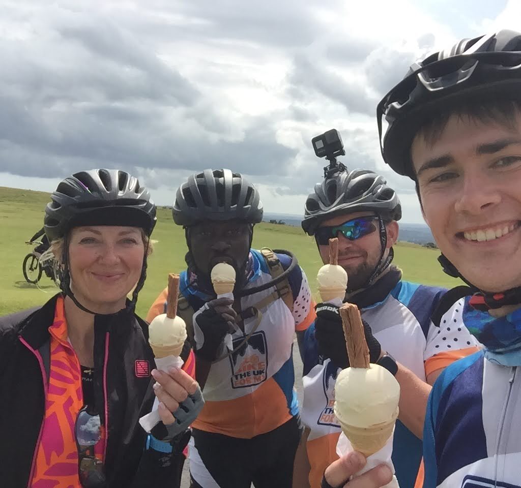 A group of cyclists smiling and holding ice creams