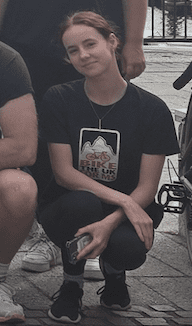 Woman crouched in a group photo, smiling at the camera