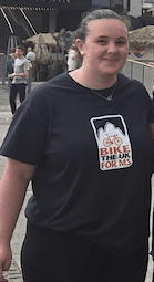 Woman stood smiling at the camera in a bike the UK for MS t-shirt